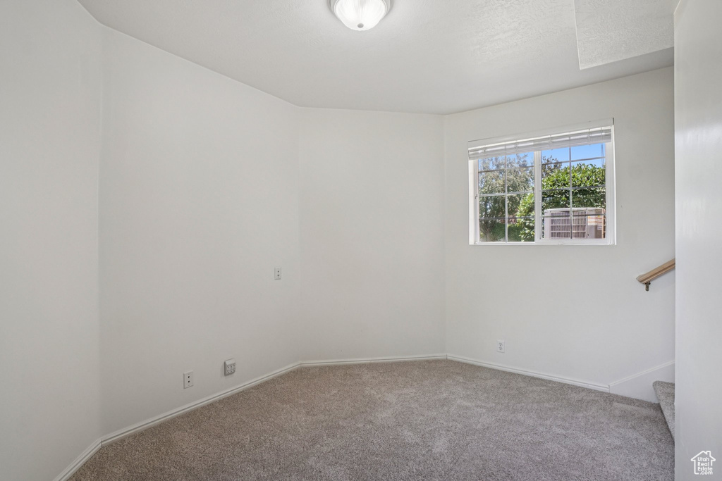 Spare room featuring carpet floors and stairs