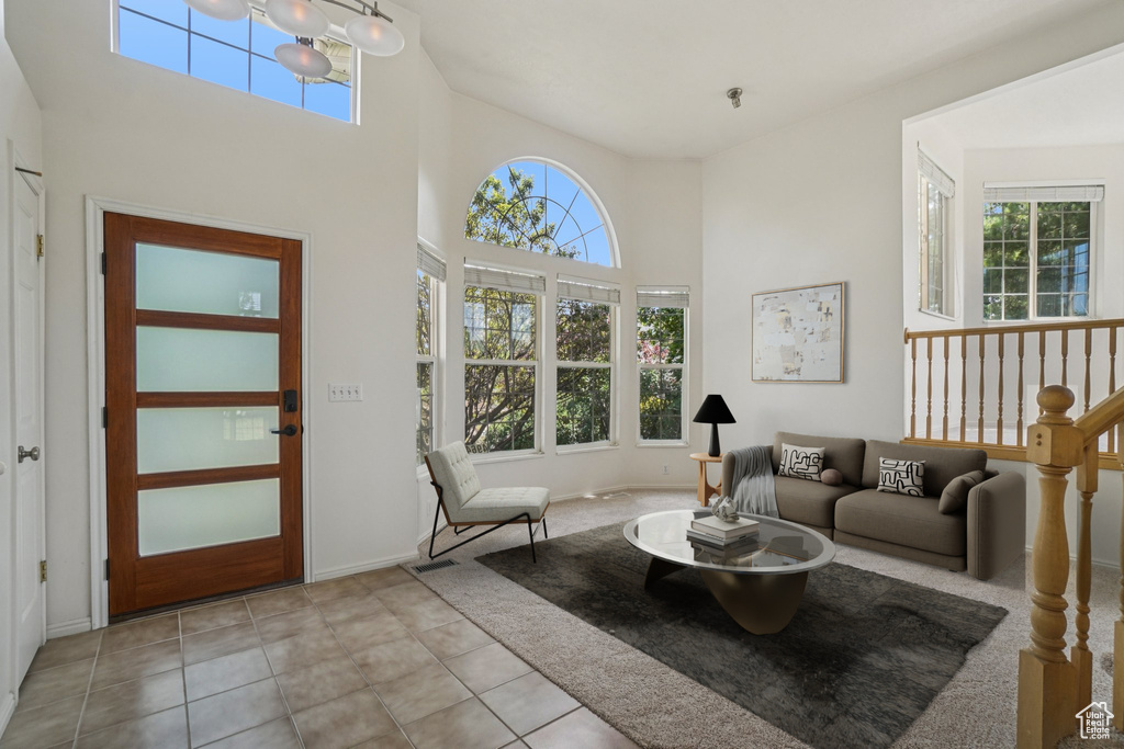 Living area featuring plenty of natural light, a high ceiling, and tile patterned flooring
