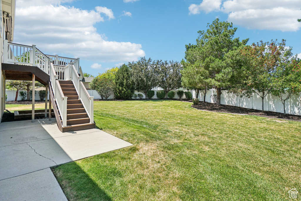 Fenced backyard with stairs, a patio area, and a wooden deck
