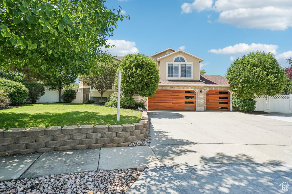 View of front facade featuring concrete driveway, brick siding, an attached garage, and stucco siding