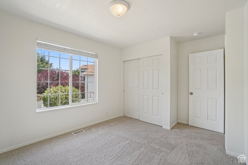 Unfurnished bedroom featuring carpet floors and a closet