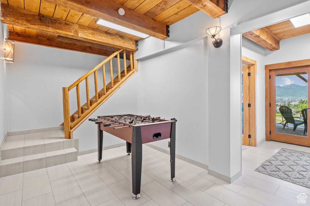 Recreation room with a wood ceiling with exposed beams and a mountain view