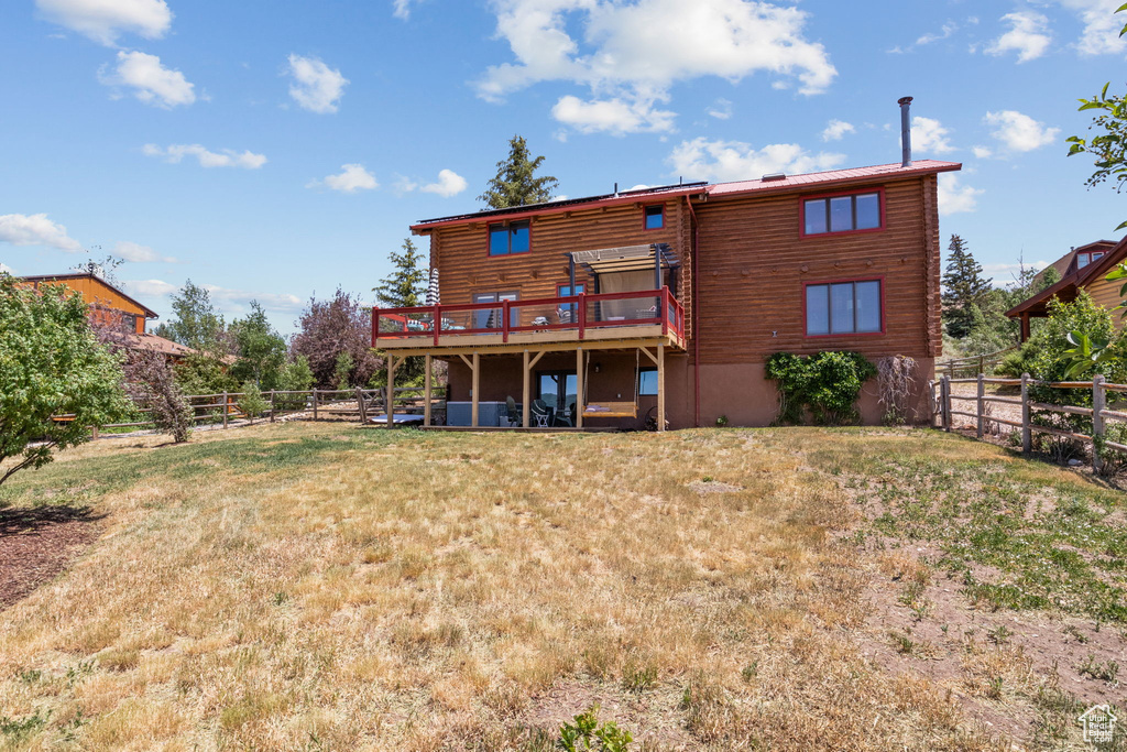 Rear view of house with a deck and log siding