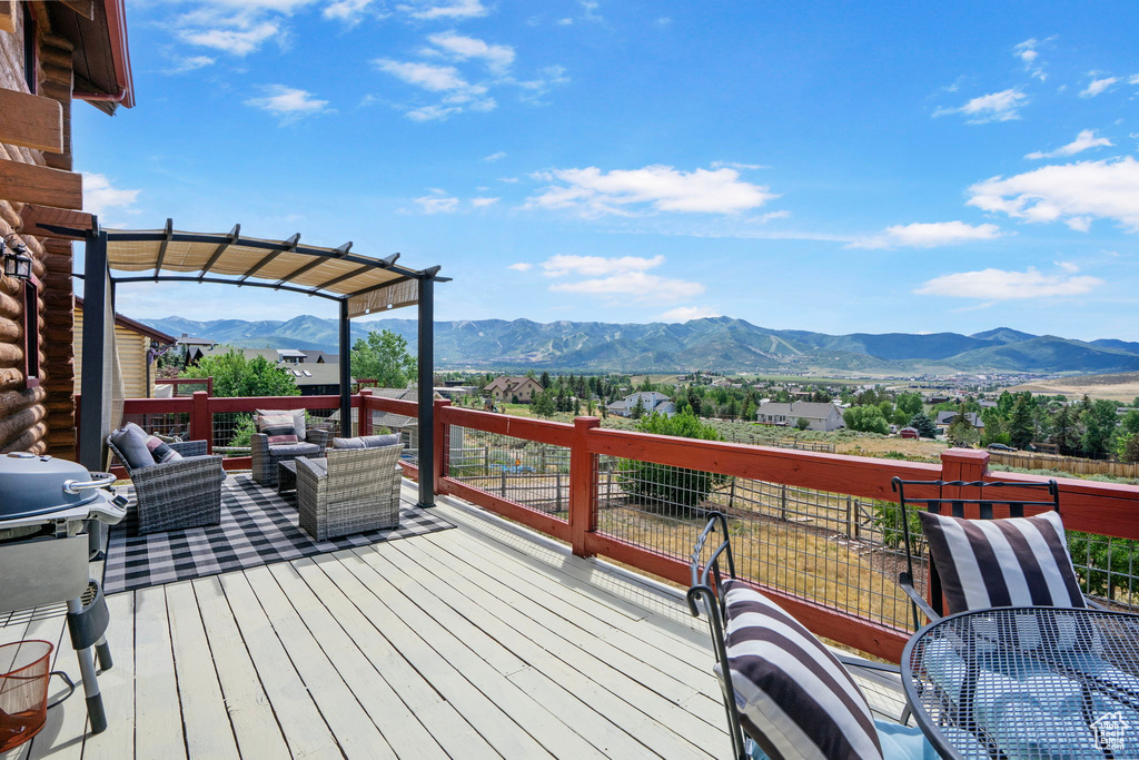 Deck featuring a mountain view, an outdoor hangout area, grilling area, and a pergola