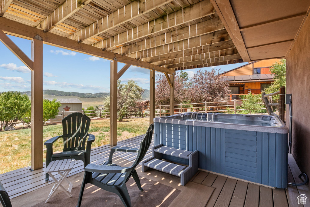 Wooden terrace featuring a hot tub and a mountain view