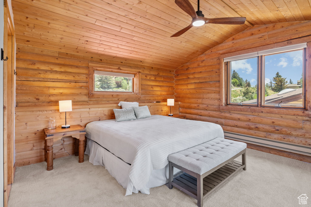 Bedroom featuring baseboard heating, light carpet, vaulted ceiling, wood ceiling, and rustic walls
