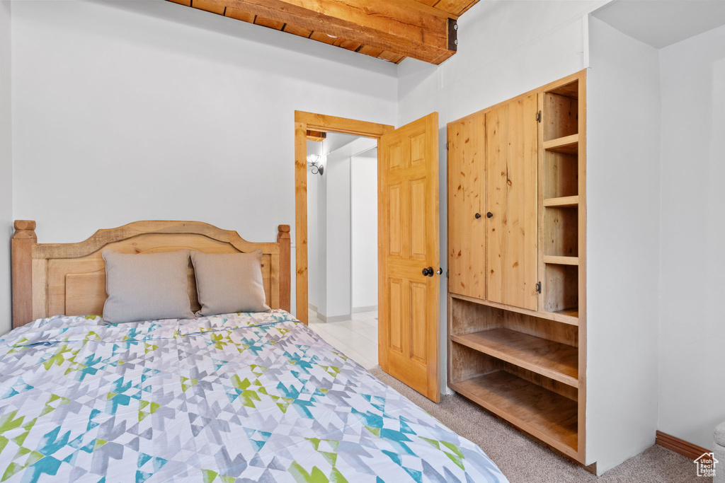 Carpeted bedroom featuring beam ceiling