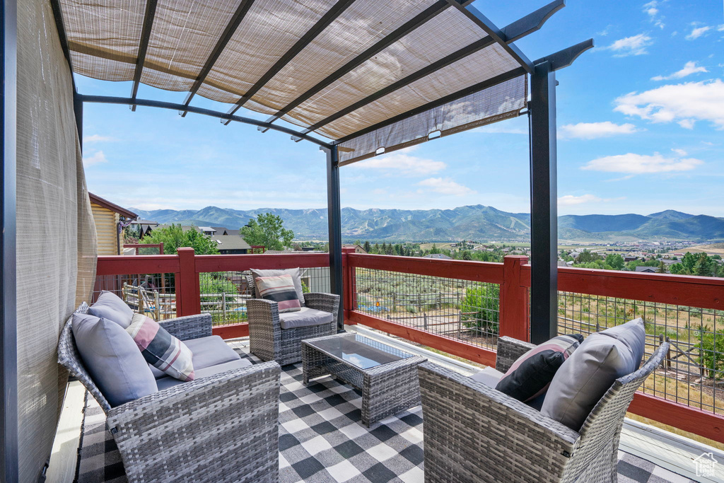 Wooden deck featuring a mountain view and an outdoor hangout area