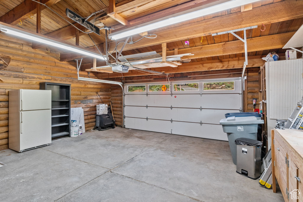 Garage with freestanding refrigerator and a garage door opener