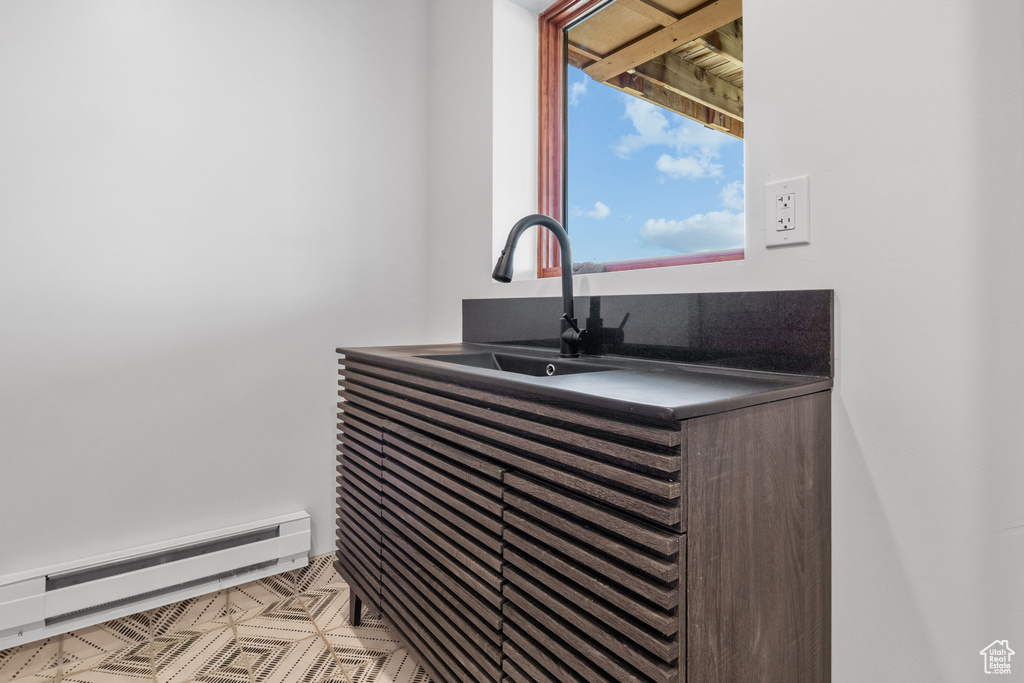 Detailed view of baseboard heating and a sink