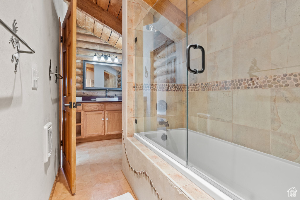 Full bathroom with vanity, tiled shower / bath combo, and beamed ceiling