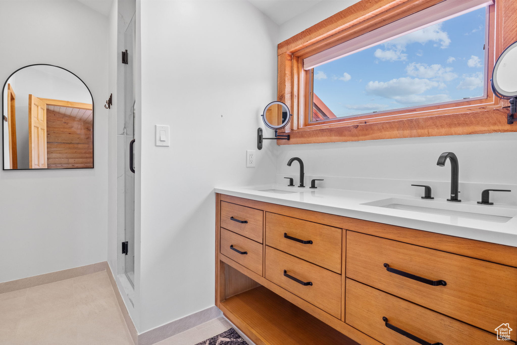 Full bath with double vanity and baseboards