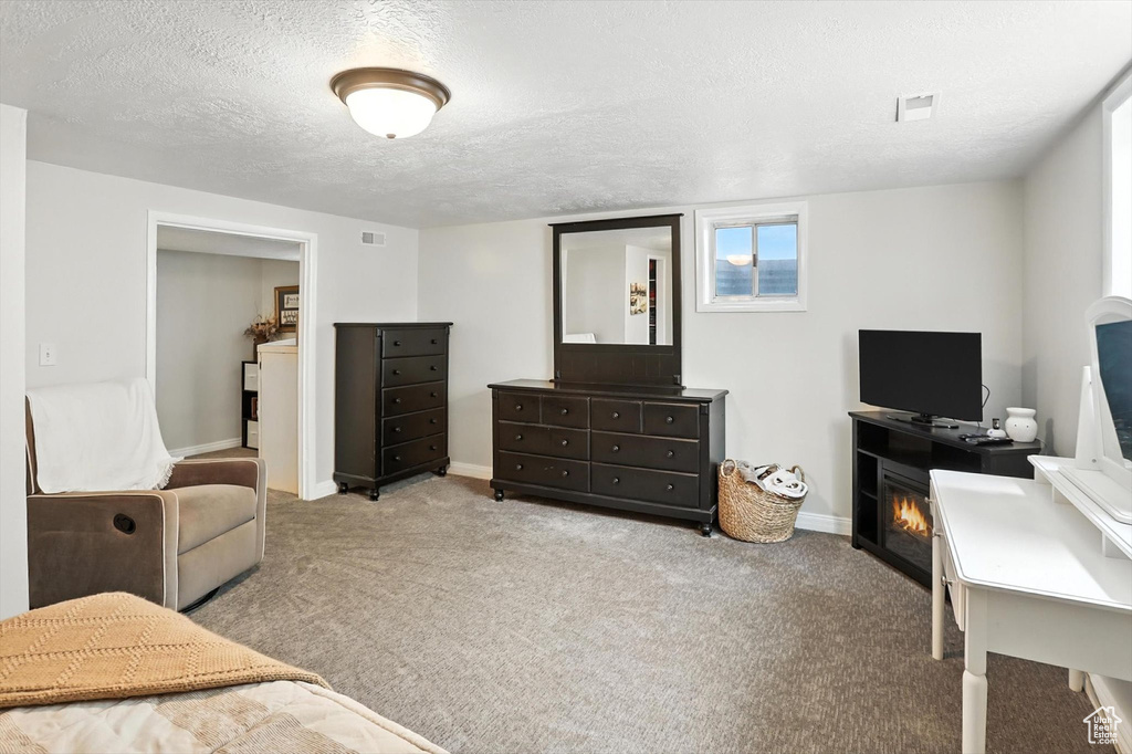 Carpeted bedroom with a textured ceiling and baseboards