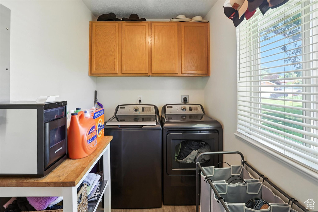 Washroom featuring washer and dryer and cabinet space