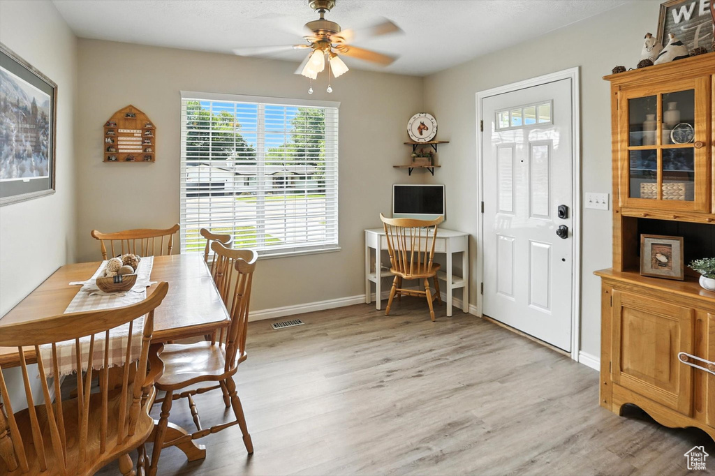 Dining space with ceiling fan and light wood-style flooring