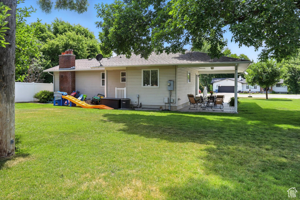 Rear view of property featuring a chimney and a patio