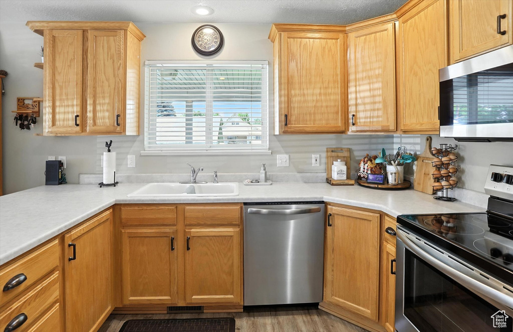Kitchen featuring stainless steel appliances, light countertops, and light wood-type flooring