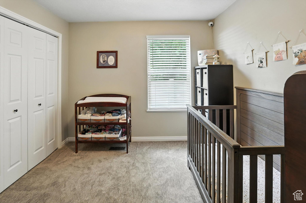 Carpeted bedroom featuring a closet and baseboards