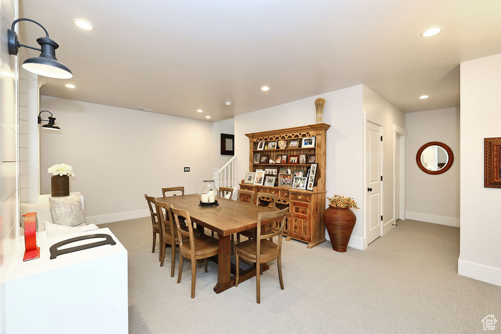 Dining space with recessed lighting, stairway, and light carpet