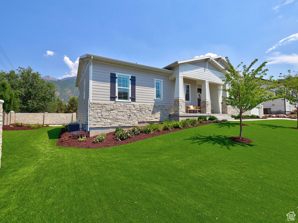 Craftsman-style house with stone siding, a mountain view, and a porch
