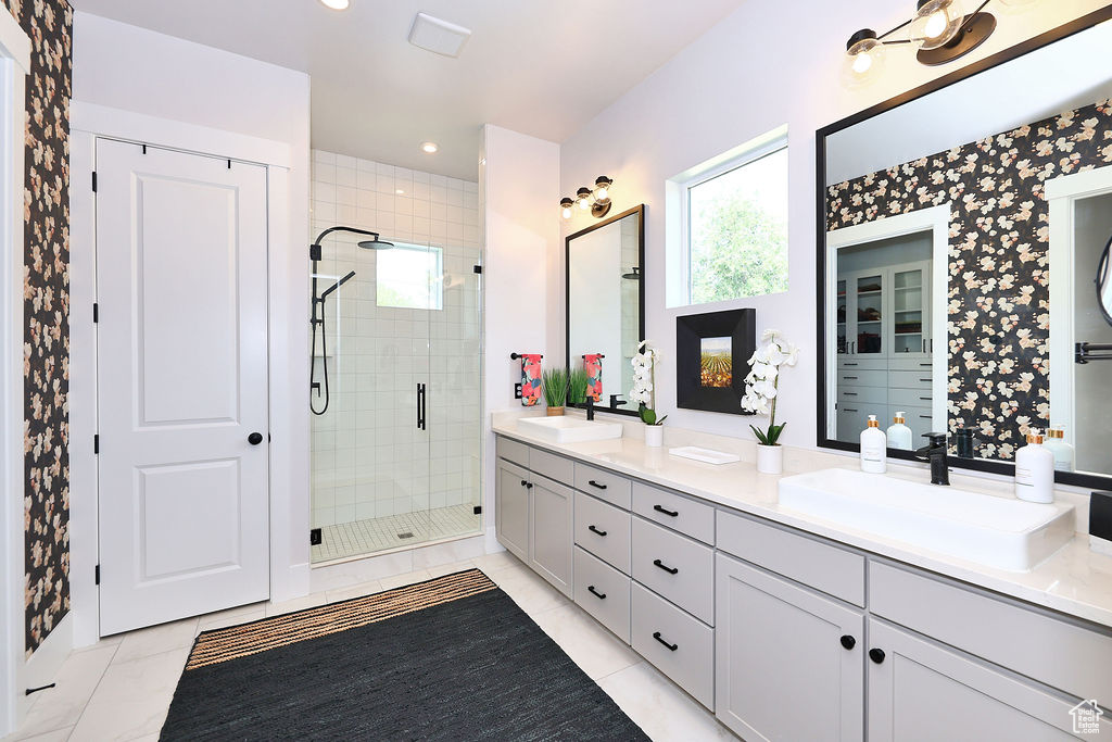 Full bath with double vanity, a stall shower, recessed lighting, and wallpapered walls