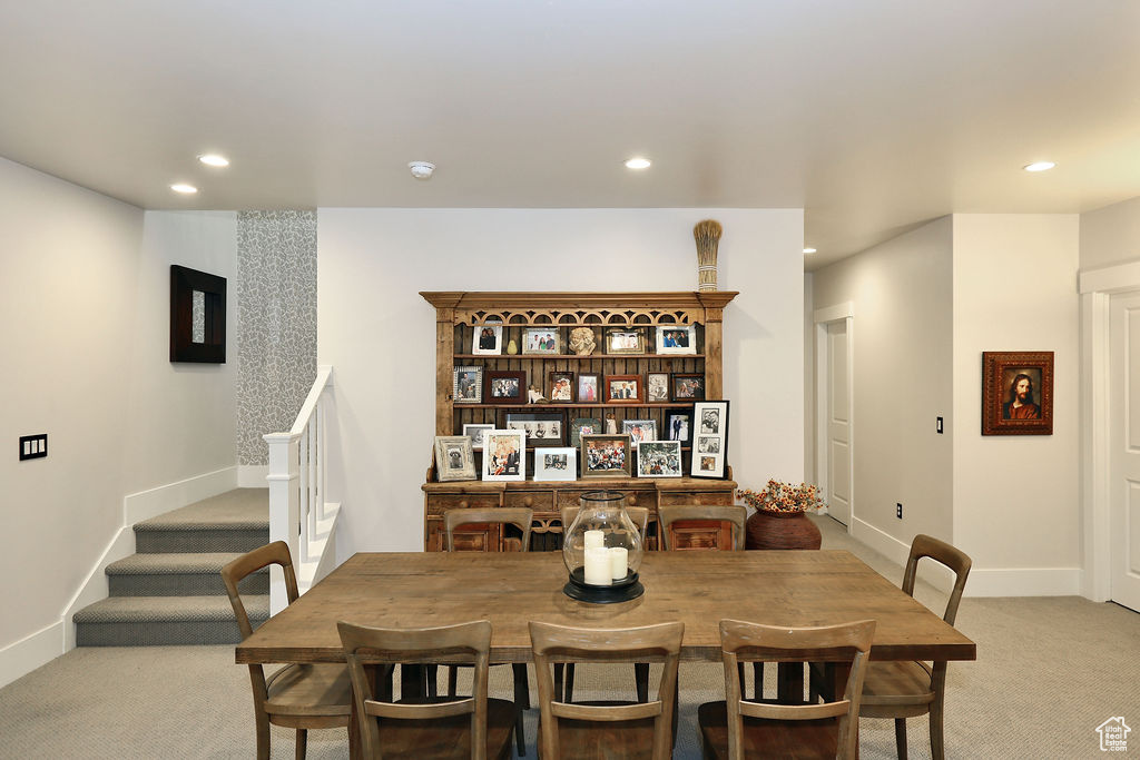Dining area with light carpet, recessed lighting, and stairway