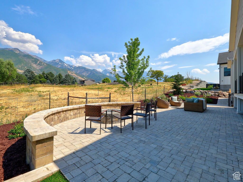 View of patio / terrace with a mountain view, an outdoor living space, and a rural view