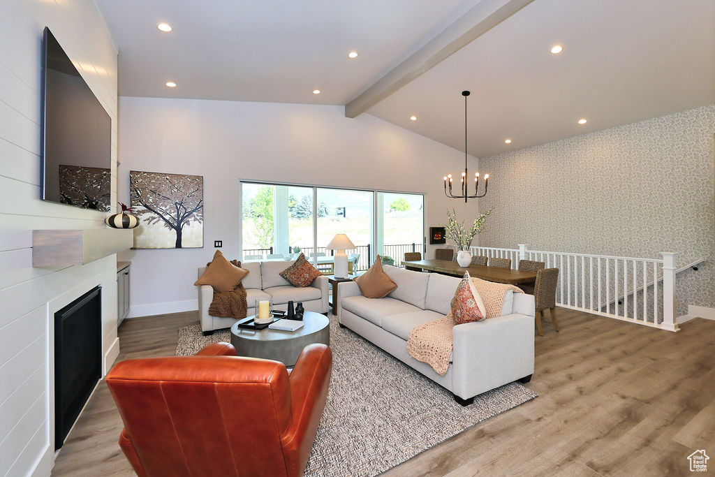Living area with a chandelier, light wood-style floors, a large fireplace, and recessed lighting