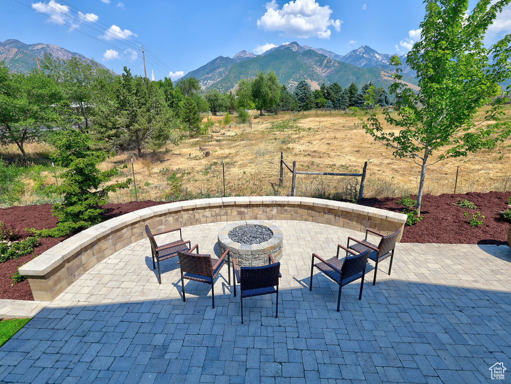 View of patio / terrace featuring an outdoor fire pit and a mountain view