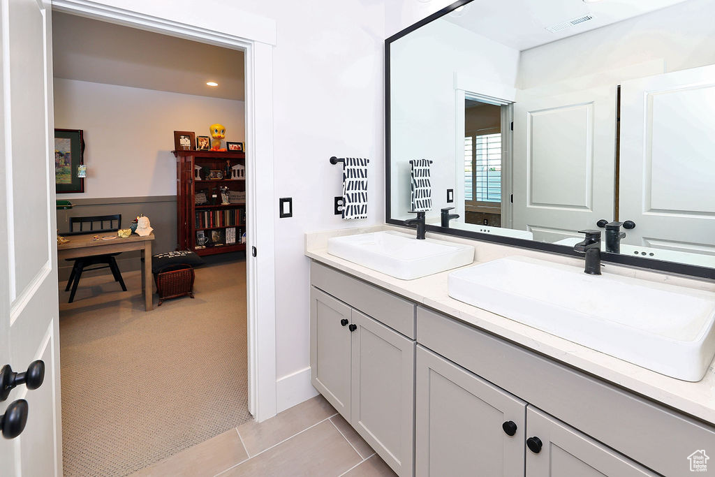 Full bath featuring double vanity and tile patterned flooring