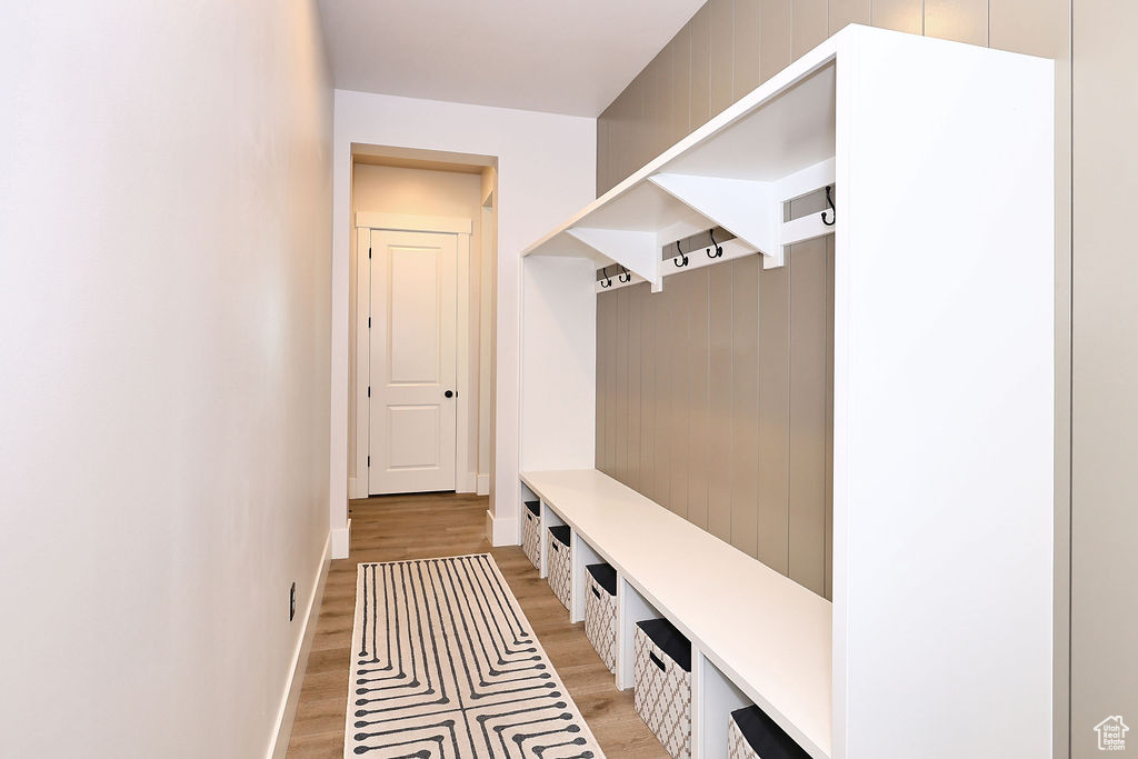 Mudroom featuring light wood finished floors and baseboards