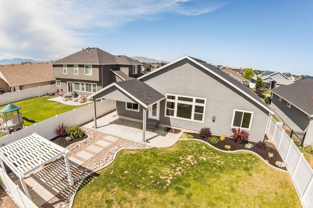 Rear view of house with stucco siding, a patio area, a fenced backyard, and a residential view