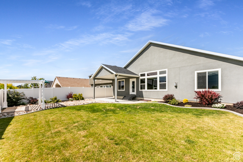 Rear view of property featuring a patio, a fenced backyard, and stucco siding