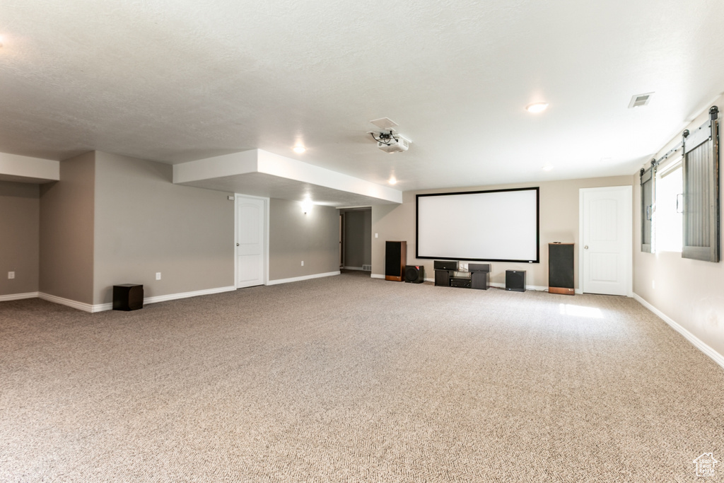 Home theater room with a barn door and carpet