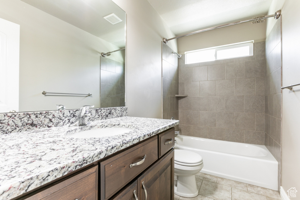 Bathroom featuring vanity, tile patterned floors, and shower / washtub combination