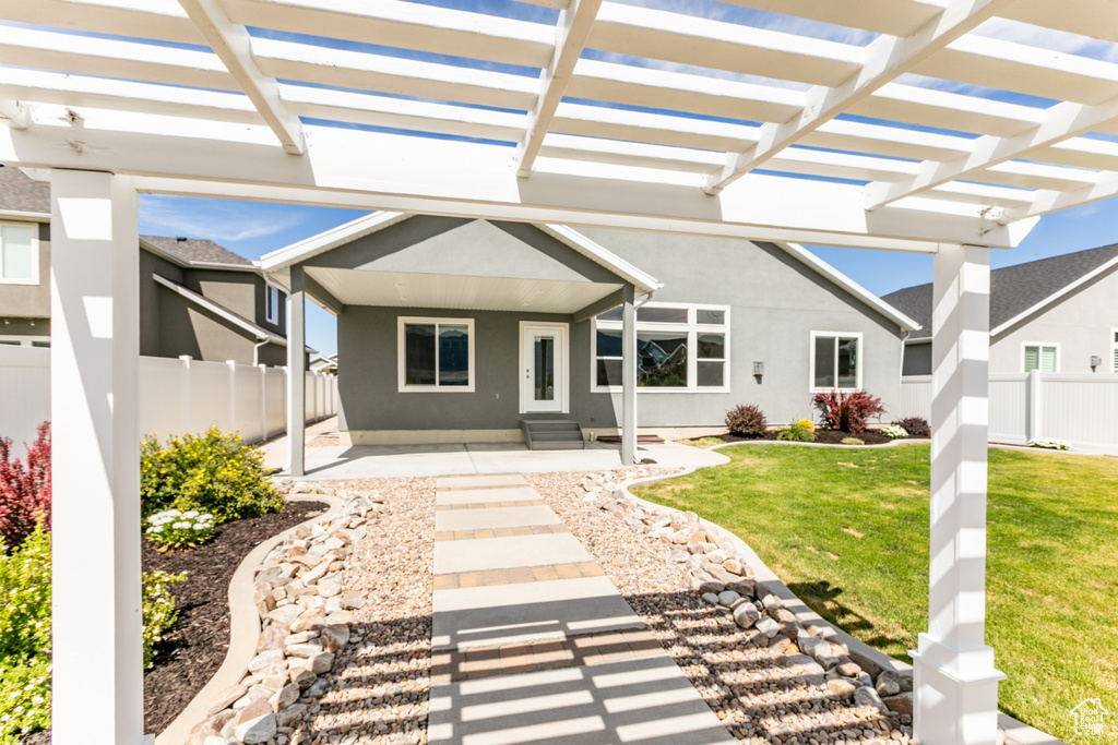 Rear view of house with stucco siding, a patio, a pergola, and entry steps