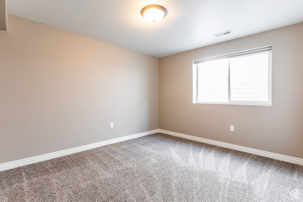 Carpeted empty room with baseboards