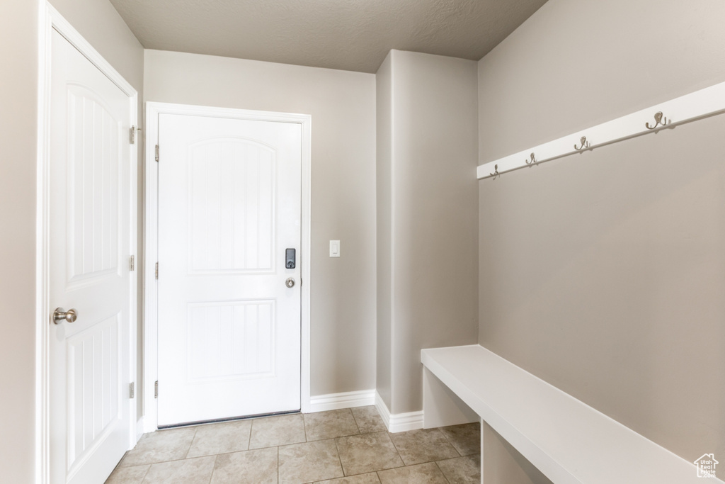 Mudroom with light tile patterned floors and baseboards