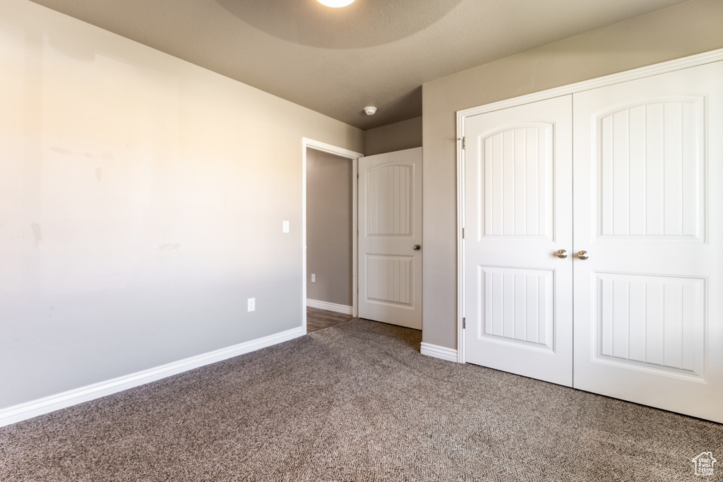 Unfurnished bedroom with carpet flooring and a closet