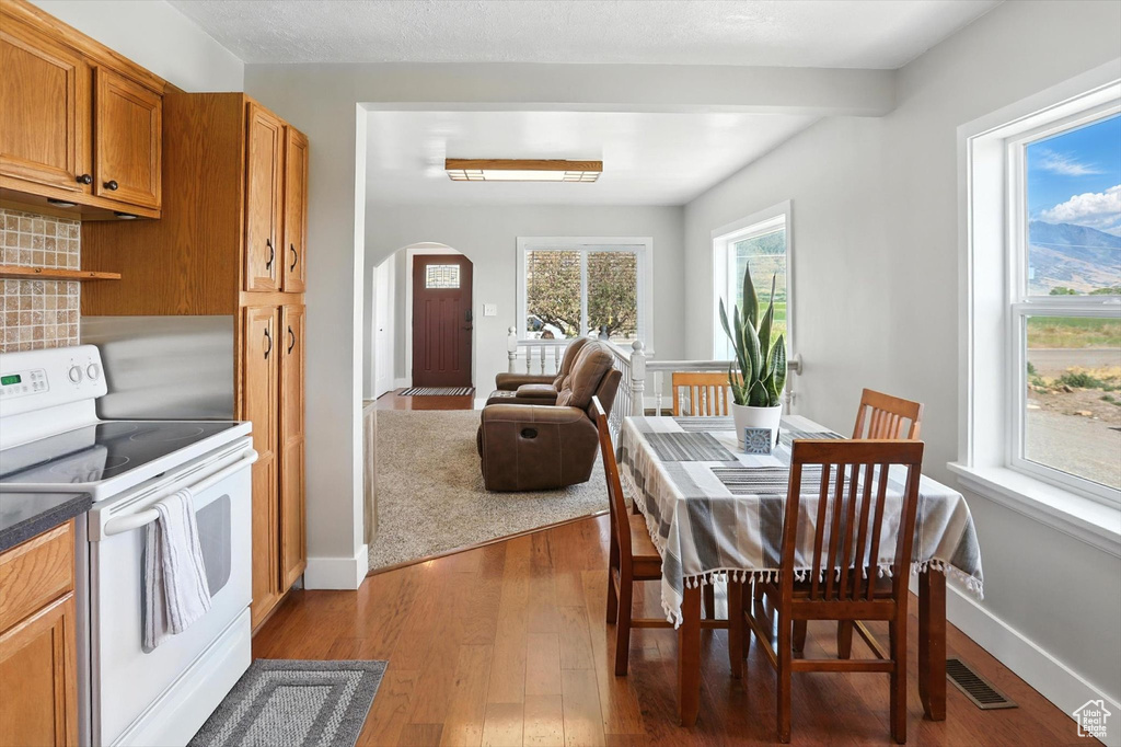 Dining room featuring arched walkways and dark wood finished floors