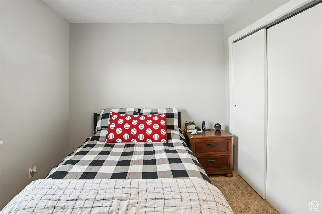 Carpeted bedroom featuring a closet