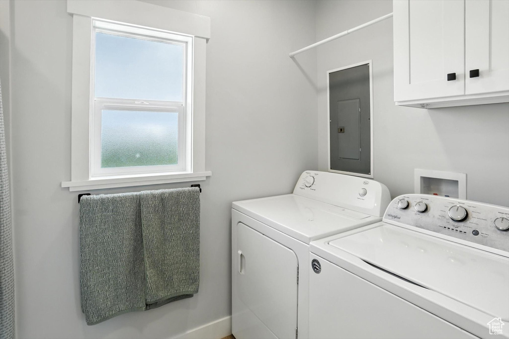 Washroom with electric panel, cabinet space, and independent washer and dryer