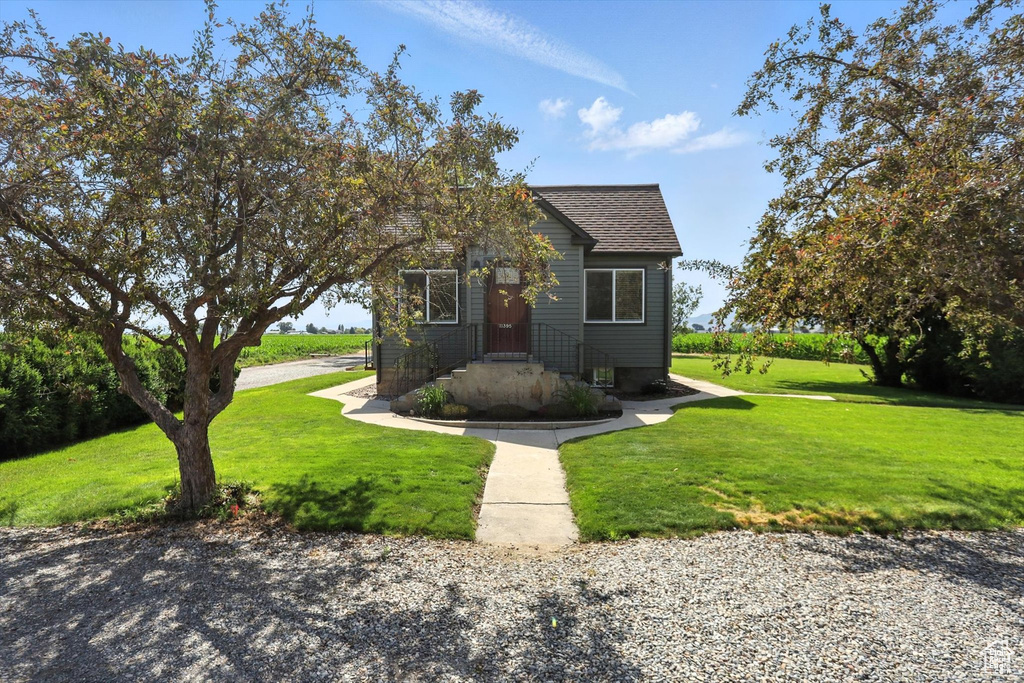 View of front facade with a front yard and roof with shingles