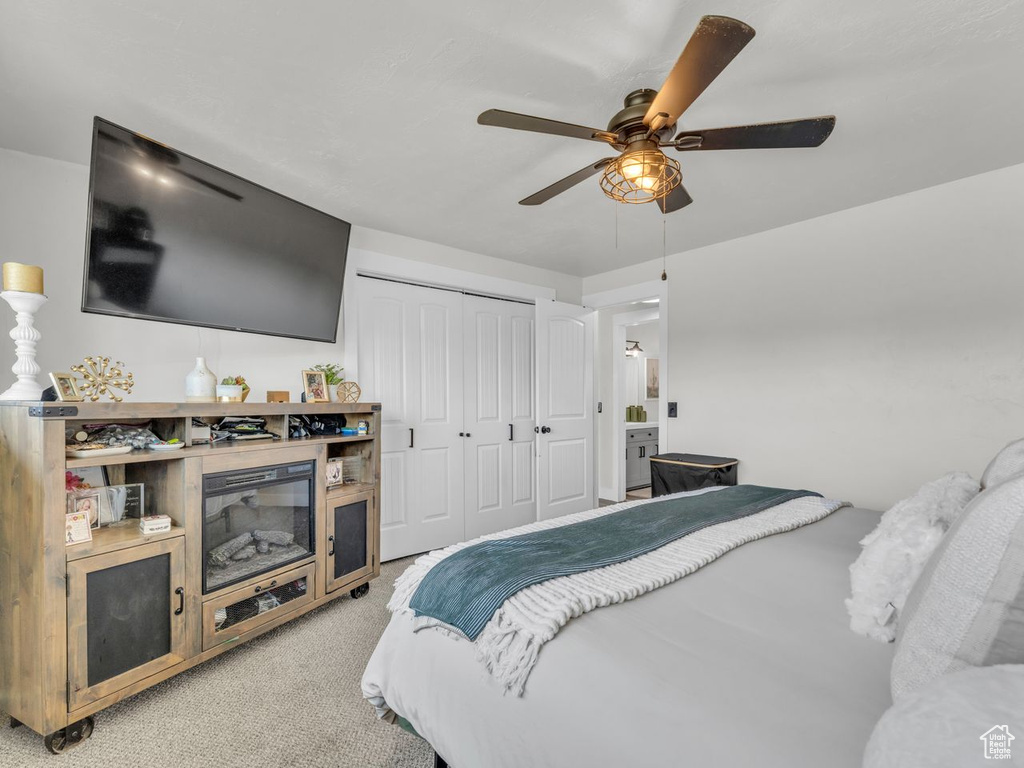 Bedroom featuring a closet, light carpet, and ceiling fan