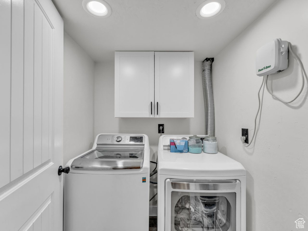 Washroom with cabinet space, washing machine and clothes dryer, and recessed lighting