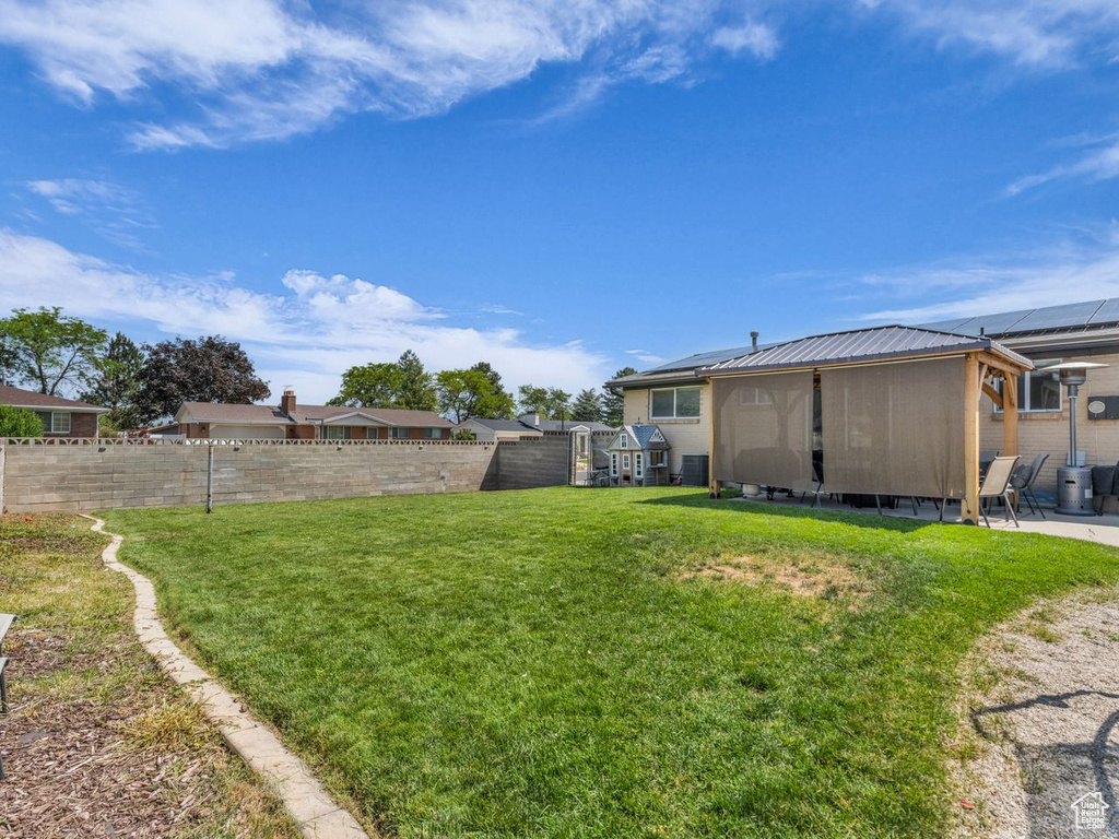 Fenced backyard with a sunroom and a patio