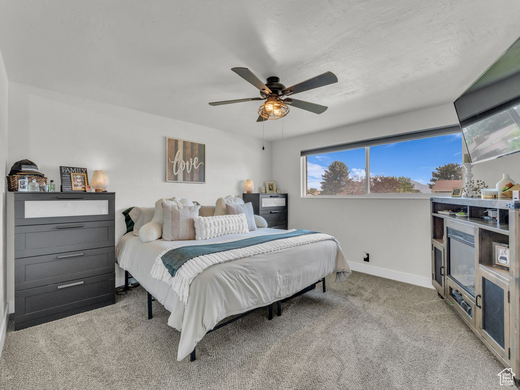 Carpeted bedroom with baseboards and a ceiling fan