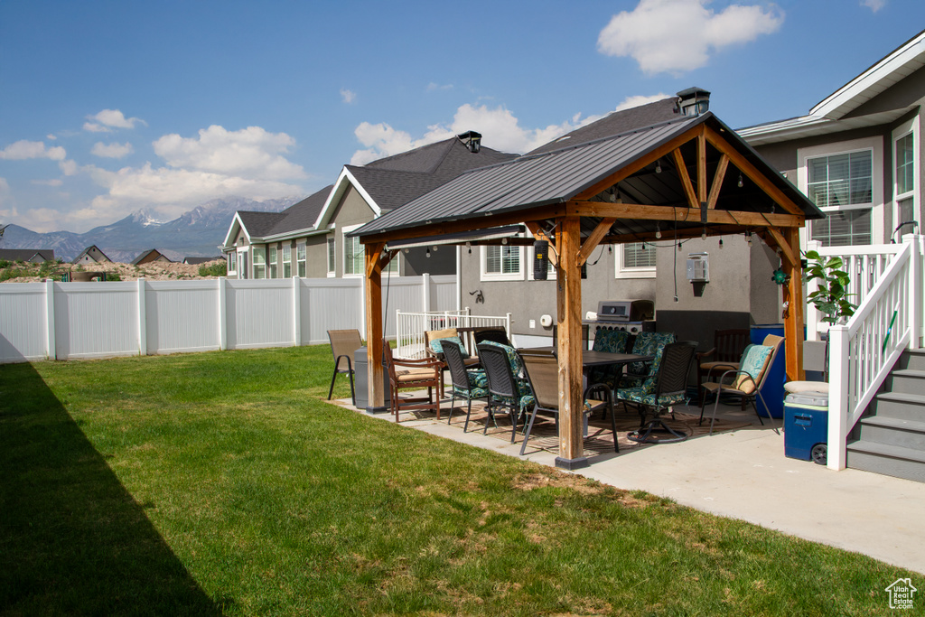 Fenced backyard with a gazebo, a patio area, and a mountain view