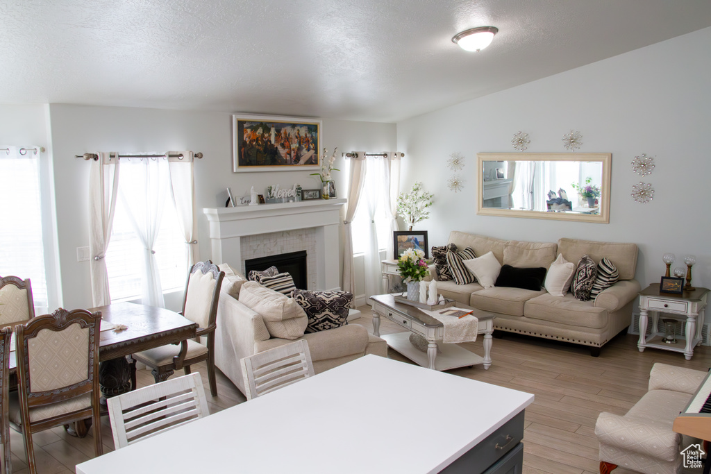 Living area with plenty of natural light, wood finished floors, and a fireplace