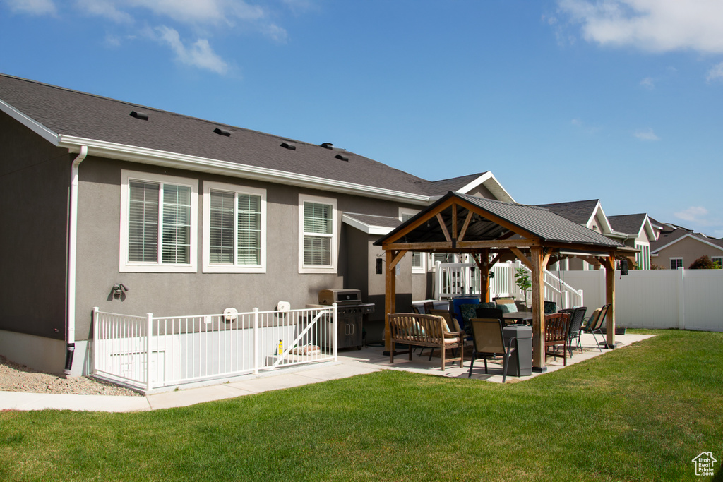 Rear view of house with a gazebo, a patio, and stucco siding
